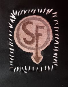 A patch I made of the design on Larry's shirt in the video game "Sally Face" It represents a metal band that Larry listens to. The design is an S and F in different shades of brown. Patch Diy Ideas, Patches Ideas Diy, Diy Pants Patches, Patches And Pins, Pant Patches, Alt Clothing Diy, Punk Patches Ideas Grunge, Fabric Patches On Clothes