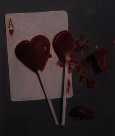 two heart shaped lollipops sitting on top of a piece of white paper