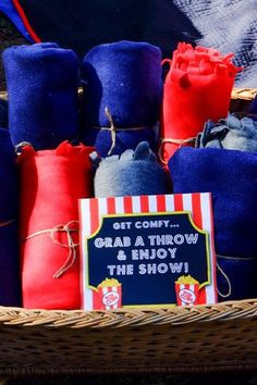 a basket filled with lots of blue and red items next to a sign that says grab a throw know the show