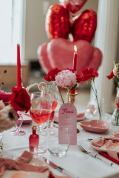 a table set for valentine's day with pink and red decorations