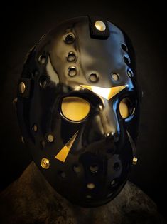 Black and Gold ultra clean Friday the 13th part 3 hockey mask. Vacuum formed with thick .118" PETG plastic. Includes all Gold colored metal hardware. This DOES NOT include the display bust the hockey mask is displayed on in the pictures. You will recieve the hockey mask only. Please be aware of our wait times when ordering. Punk Black Masks For Costume, Jason Voorhees Mask, Halloween Hockey Mask, Goalie Mask Designs, Hockey Goalie Mask Design, Jason Friday, Jason X, Jason Mask, Gas Mask Art