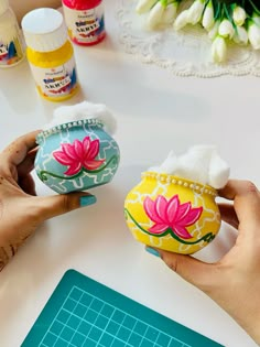 two hand painted vases sitting on top of a table