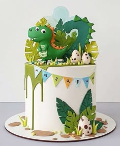 a birthday cake decorated with an image of a dinosaur and eggs in the shape of leaves