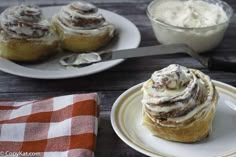 two plates with pastries on them next to a bowl of whipped cream