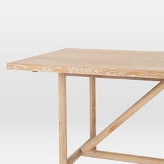 a wooden table with two crossed legs and a square top, on a white background