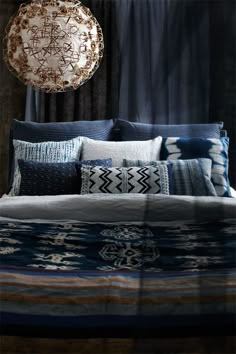 a bed with blue and white pillows on top of it