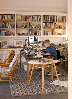 a man sitting at a desk in front of a bookshelf filled with books