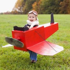 a young child is sitting in an airplane costume