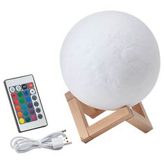 a large white ball sitting on top of a wooden stand next to a remote control