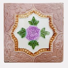 a pink and white tile with a purple flower on it