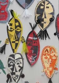 several colorful masks are hanging on the wall