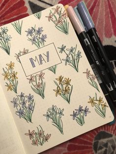 an open notebook with flowers and the word may written on it