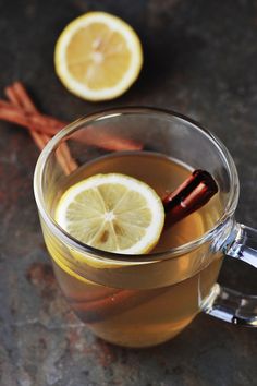 a cup of tea with lemon and cinnamon on the side