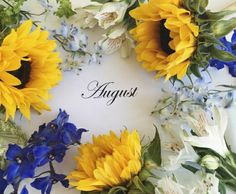 sunflowers and blue flowers are arranged around the word august