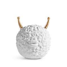 a white vase with horns on it's head and curls in the shape of a face