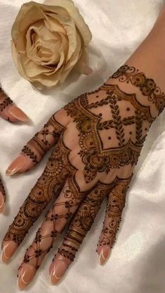 two hands with henna designs on them and a flower in the middle of each hand