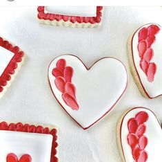 cookies decorated with red and white icing in the shape of hearts