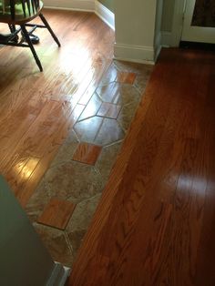 a wooden floor in a kitchen with hard wood floors and tile on the flooring