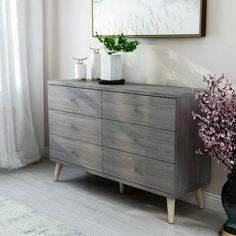 a wooden dresser with two vases on top of it