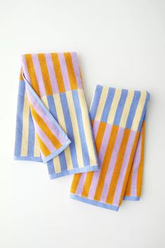 two towels folded on top of each other, one with blue and yellow striped design