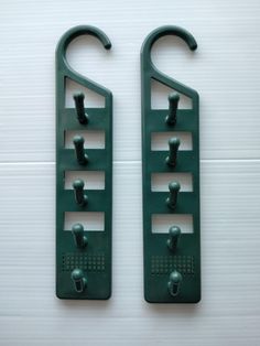 two green hooks are attached to the wall