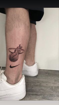 a man's leg with a tattoo on it and a tennis shoe next to him