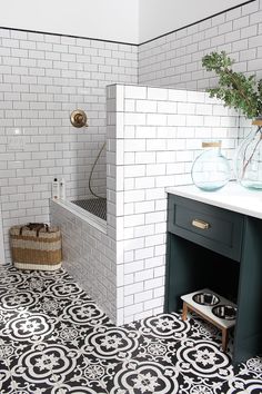 a bathroom with black and white tiles on the floor