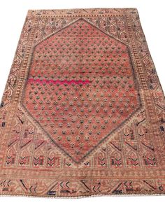 an antique persian rug with geometric design on the middle, and pink border around the edges