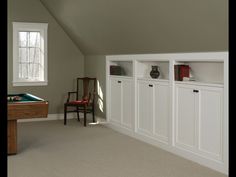 a room with some white cabinets and a pool table