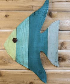 a fish made out of wooden planks sitting on top of a wood floor next to a wall