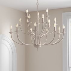 a chandelier hanging from the ceiling in a room with beige walls and white trim