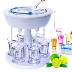 an ice bucket filled with glasses next to limes and shot glasses on a table