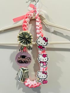 the hello kitty hair tie is hanging on a hanger with other items attached to it