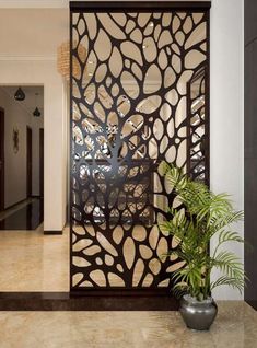 a plant is sitting in front of a decorative screen on the entrance to a house