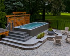 an outdoor hot tub surrounded by patio furniture