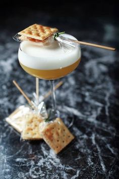 a drink with cheese and crackers on top