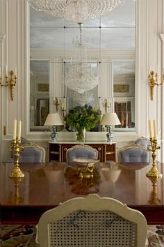 an elegant dining room with chandelier and blue upholstered chairs in the center