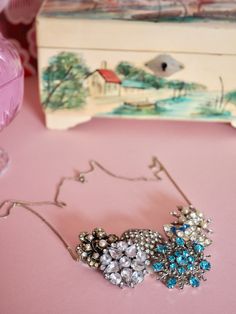 a pair of blue and white brooches sitting on top of a pink table