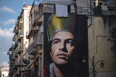 a large mural on the side of a building with a man's face painted on it