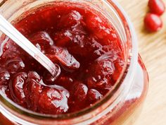 a jar filled with jam sitting on top of a wooden table