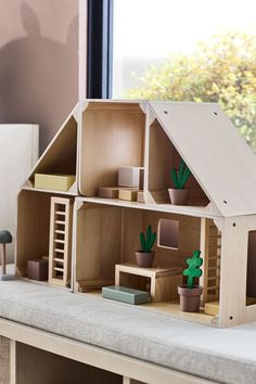 a doll house with wooden furniture and cactus plants