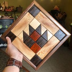 a person holding up a wooden art piece