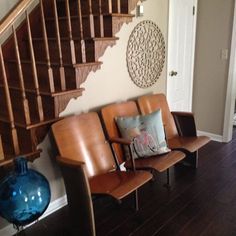 a couple of chairs sitting in front of a stair case next to a blue vase