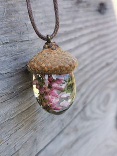 a glass jar filled with flowers hanging from a rope