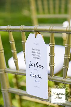 a chair with a sign attached to it that says father of the bride and groom