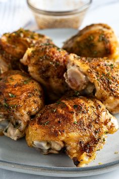 some chicken wings on a plate with seasoning