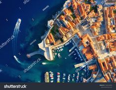 an aerial view of boats in the water and buildings on the shore, taken from above