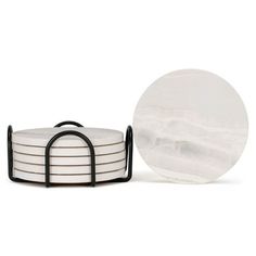 a stack of white plates sitting on top of a black metal rack next to a round plate