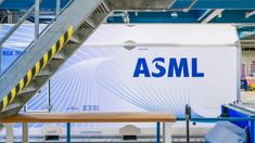 the asml truck is parked next to some stairs and railings in an industrial building