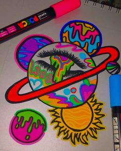 an art project with markers and crayons on the table next to it is a drawing of saturn